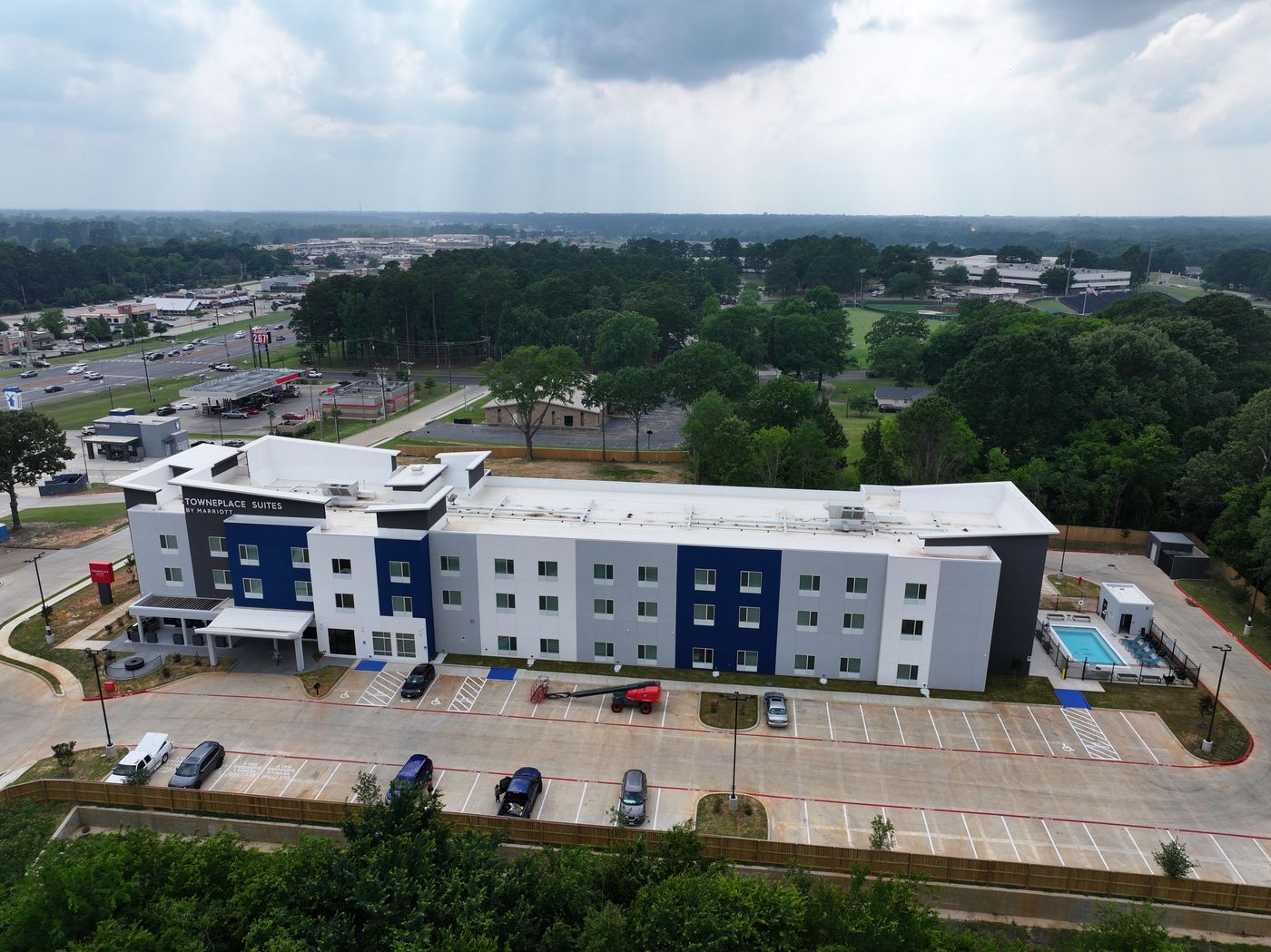Aerial of a completed four-story hotel with pool