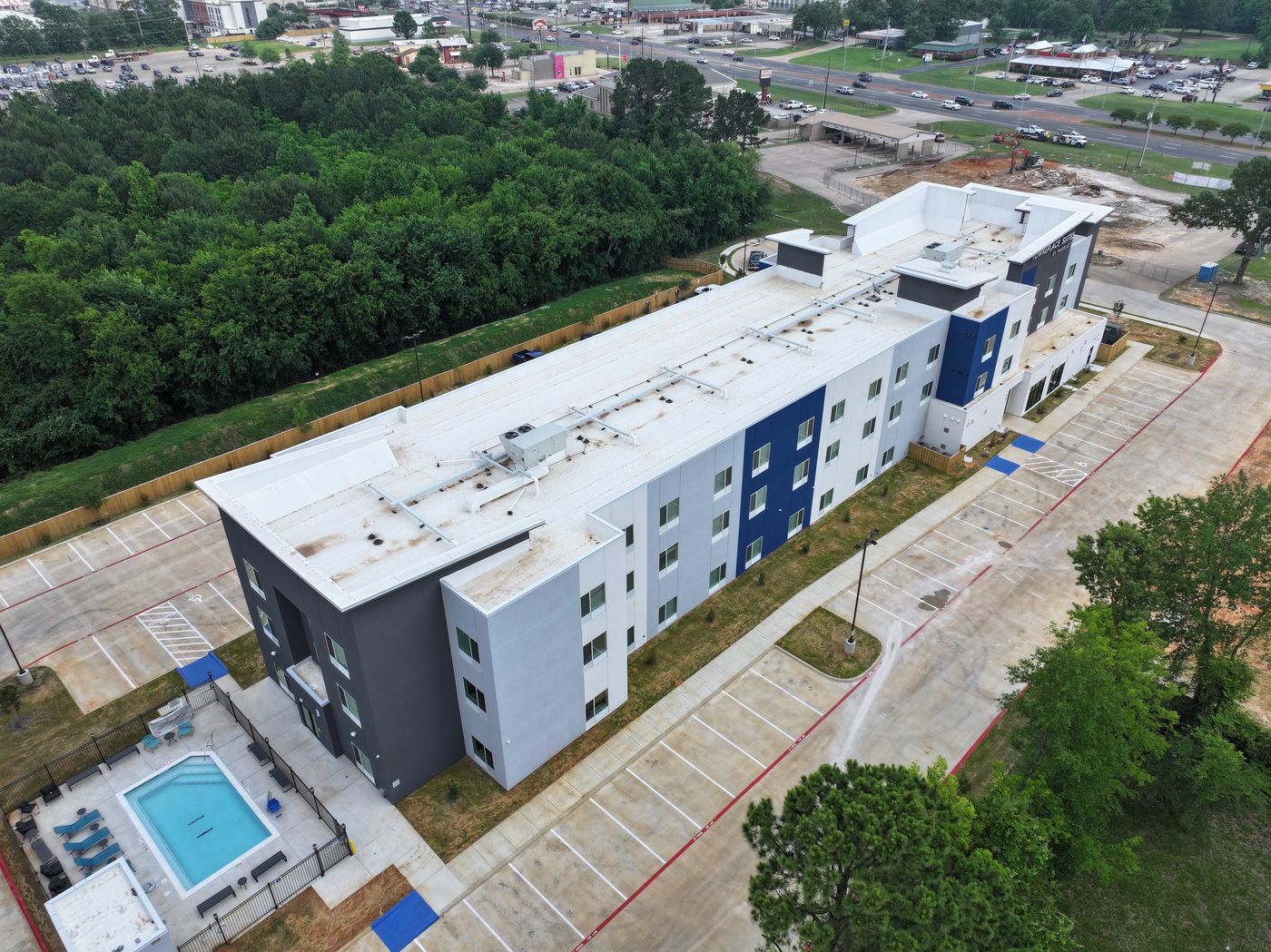 Aerial of a four-story extended-stay hotel with pool
